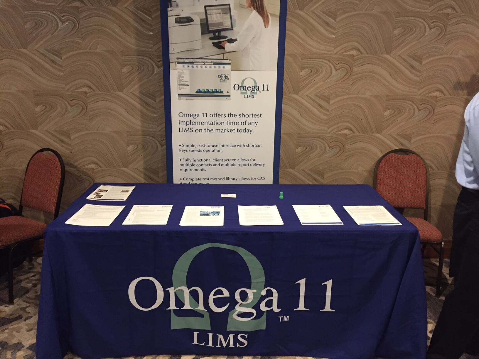 A table with papers and an omega 1 1 logo on it.